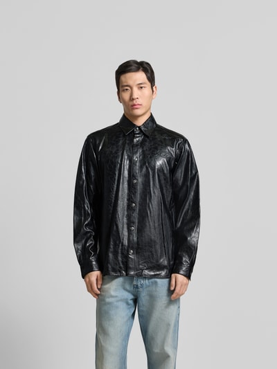 Männermodel trägt Freizeithemd aus reiner Viskose von Diesel in Leder-Optik, schwarz, Regular Fit, Kentkragen, Ganzkörperansicht von vorne.