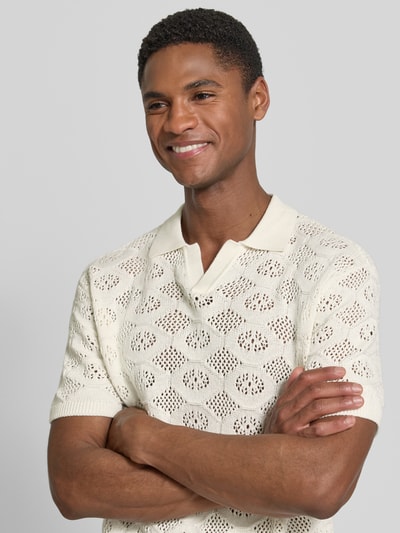 Männermodel trägt Slim Fit Poloshirt in Strick-Optik Modell 'Angvig' von Casual Friday, semitransparent, cremefarben, Nahaufnahme Oberkörper.