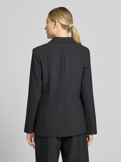 Frauenmodel trägt Regular Fit Blazer mit Reverskragen Modell 'Leonora' von MOS MOSH, czarny, gładka faktura, Ganzkörperansicht Rückansicht. Żakiet, krój regular fit, kołnierz z połami, zapięcie na guzik, długość tyłu w rozmiarze 36: 66 cm, szerokość w rozmiarze 36: 40 cm, długość rękawów w rozmiarze 36: 62 cm.