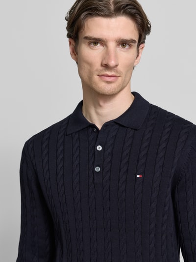 Männermodel trägt Regular Fit Strickpullover aus reiner Baumwolle von Tommy Hilfiger, unifarben mit Zopfmuster, Nahaufnahme Oberkörper