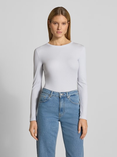 Frauenmodel trägt Slim Fit Langarmshirt aus Lyocell-Mix von Marc O'Polo, Optik: Unifarben, Passform: Slim-Fit, Rundhals, Ärmelform: Langarm, Materialverarbeitung: Ripp, Farbe Weiß, glatte Textur, Ganzkörperansicht von vorne.