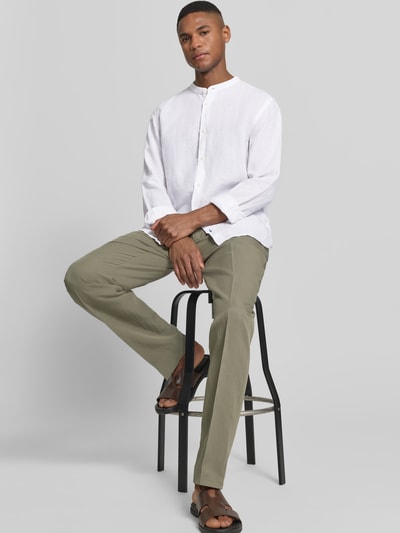 Männermodel trägt Slim Fit Leinenhemd aus reinen Leinen mit Stehkragen von OLYMP Level Five, weiß, langärmelig, Ganzkörperansicht von vorne, Rückenlänge bei Größe M 75 cm, Schulterbreite 48 cm, Ärmellänge 64 cm, Sportmanschetten, durchgängige Knopfleiste.