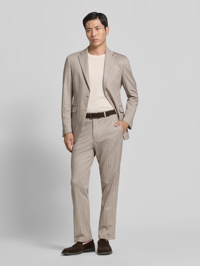Männermodel trägt Regular Fit Sakko mit Viskose-Anteil Modell 'Calvin' von CG - Club of Gents in Beige mit Nadelstreifen, Ganzkörperansicht von vorne. Sakko mit Reverskragen, Pattentaschen, Brusttasche, 2-Knopf-Leiste und Logo-Detail, elastischer Material-Mix, strukturierte Oberfläche.