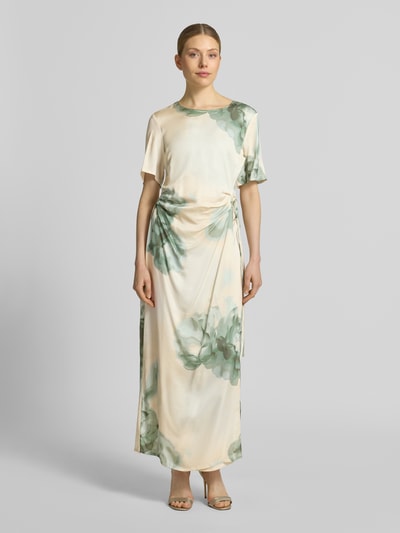 Frauenmodel trägt Maxikleid in Wickel-Optik mit Schnürung Modell 'Kylar' von mbyM aus Reine Viskose, taillierter Schnitt, Rundhalsausschnitt, florale Muster in Grün und Creme, glatte Textur, Rückenlänge bei Größe S: 140 cm, Brustweite: 48 cm, Ärmellänge: 27 cm, Ganzkörperansicht von vorne.