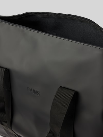 Productfoto, zwarte weekendtas van glad materiaal met logodetail, Model 'Hilo' van Rains, hoofdvak met ritssluiting, afneembare schouderband, breedte 64 cm, lengte 40 cm, diepte 24 cm, schouderbandlengte 84 cm