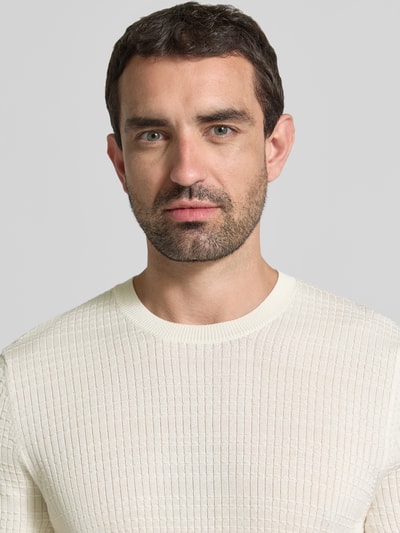 Mężczyzna nosi Strickshirt mit Strukturmuster Model 'Elio' von JOOP! COLLECTION z bawełny, krój slim fit, okrągły dekolt, fakturowany wzór, jasny kolor, faktura prążkowana, Nahaufnahme górnej części ciała.