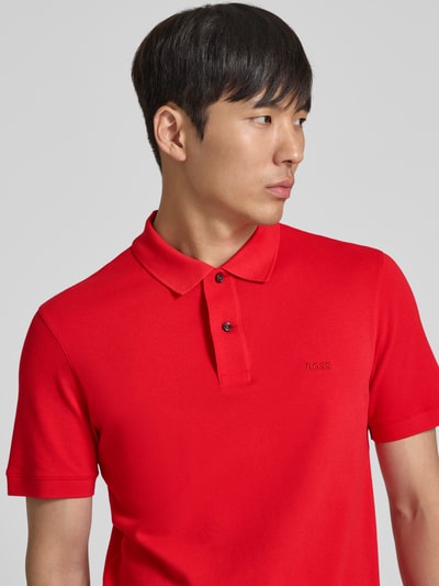 Männermodel trägt Regular Fit Poloshirt aus reiner Baumwolle Modell 'PALLAS' von BOSS, Optik: Unifarben, Nahaufnahme Oberkörper.
