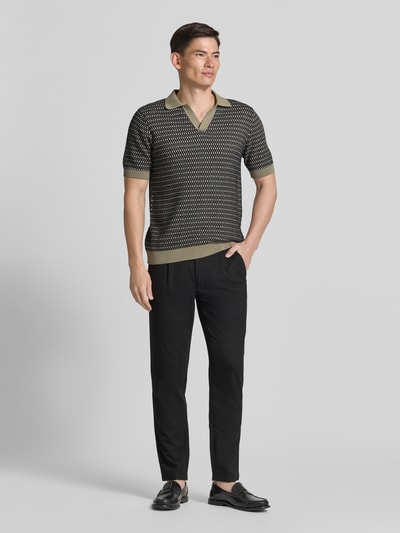 Männermodel trägt Relaxed Fit Strick-Poloshirt mit V-Ausschnitt von Lindbergh in Schwarz-Beige, Allover-Look, Reine Baumwolle, Ganzkörperansicht von vorne.