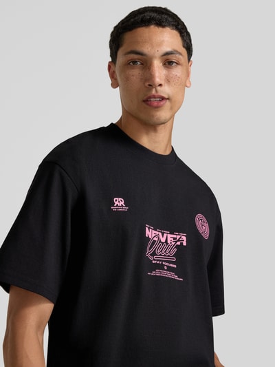 Männermodel trägt Herren T-Shirt mit Statement-Print und Rundhalsausschnitt von Redefined Rebel, Baumwoll-Mix, Relaxed-Fit, Nahaufnahme Oberkörper.