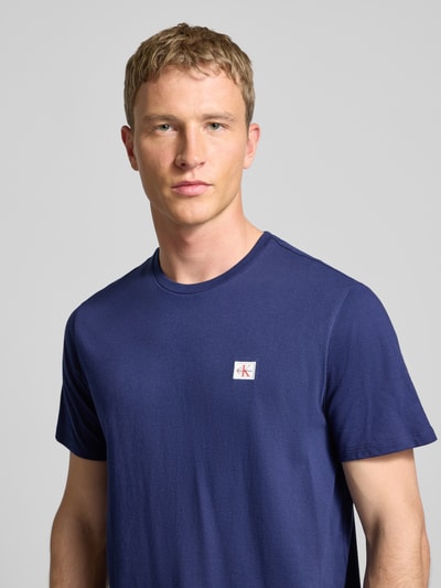 Männermodel draagt T-shirt met labeldetail im set van 2 van Calvin Klein Jeans in donkerblauw, puur katoen, regular fit, ronde hals, Nahaufnahme Oberkörper.