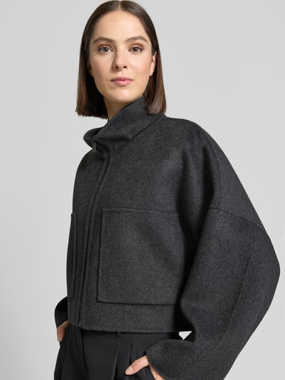 Frauenmodel trägt dunkelgraue Jacke aus Woll-Mix mit Reißverschluss Modell 'ELSTOW' von DRYKORN, Boxy Fit, Nahaufnahme Oberkörper.