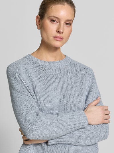 Frauenmodel trägt Oversized Strickpullover aus Baumwoll-Mix von Marc O'Polo in Hellblau, unifarben, Strickstruktur, Nahaufnahme Oberkörper.