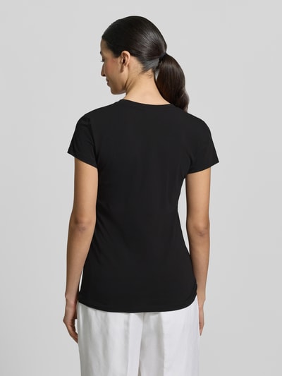 Frauenmodel trägt T-Shirt mit V-Ausschnitt und Label-Stitching von Armani Exchange aus Baumwoll-Elasthan-Mix, Regular-Fit, Rückenlänge 63 cm, Ganzkörperansicht Rückansicht.