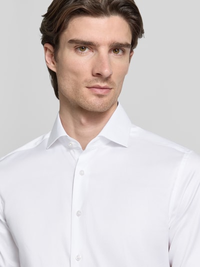 Męski model nosi Slim Fit Businesshemd in Premiumqualität od ETERNA, biała gładka tkanina, kołnierzyk włoski, krój slim fit, zbliżenie górnej części ciała