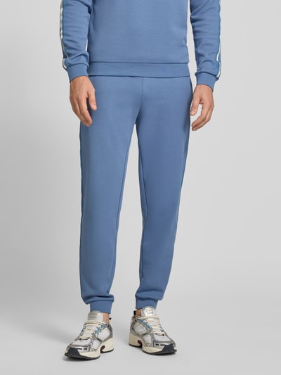 Männermodel trägt Sweatpants mit elastischem Bund von EA7 Emporio Armani in Blau, Baumwoll-Mix, Regular Fit, Nahaufnahme Unterkörper.