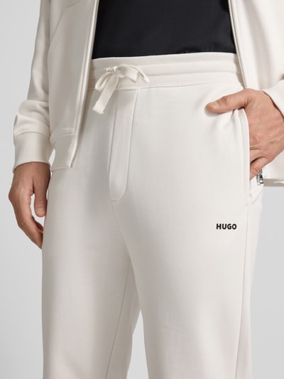 Männermodel trägt Regular Fit Jogginghose aus reiner Baumwolle Modell 'DAYOTE232' von HUGO, Optik: Unifarben, Label-Print, Sweat, Nahaufnahme Oberkörper.