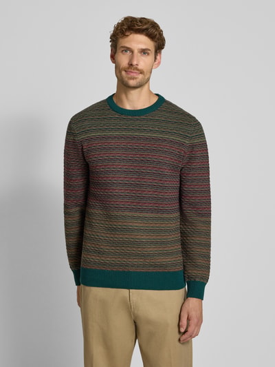 Männermodel trägt Regular Fit Pullover aus reiner Baumwolle in Strick-Optik von MCNEAL, grün-braune Farben, elastische Abschlüsse, Ganzkörperansicht von vorne.