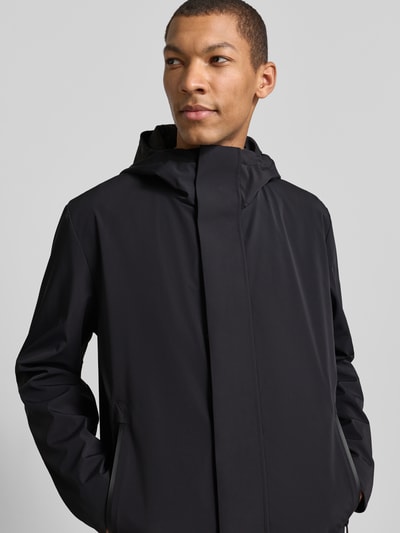 Männermodel trägt Regular Fit Funktionsmantel aus wasserabweisendem Material von Strellson in Unifarben mit Kapuze, Nahaufnahme Oberkörper.