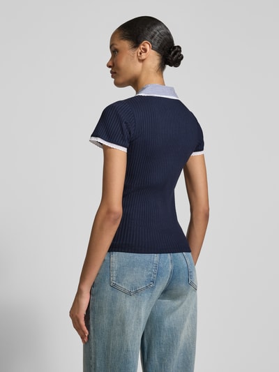 Modelka nosi Strickshirt mit Hemdblusenkragen od Rich & Royal, granatowy bawełniano-elastanowy krój slim fit, prążkowana faktura, widok całej sylwetki z tyłu.