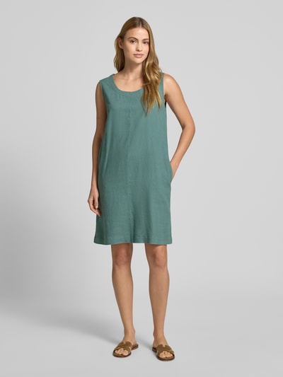 Vrouwenmodel draagt knielang, recht knielengte jurkje van mix van linnen en viscose, model 'LAVA' van FREE/QUENT in groen, daydress. Ganzkörperansicht van voren.