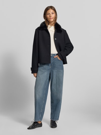 Frauenmodel trägt Baggy Fit Jeans im 5-Pocket-Design von MYON aus reiner Baumwolle in Mittelblau, Knopf- und Reißverschluss, Ganzkörperansicht von vorne.