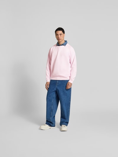 Männermodel trägt Relaxed Fit Sweatshirt aus Baumwolle von Closed in Rosa mit Raglanärmel, Rundhalsausschnitt, elastische Abschlüsse, Ganzkörperansicht von vorne. Rückenlänge bei Größe M 71 cm.