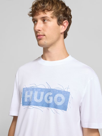 Męski model nosi Regular Fit T-Shirt aus reiner Baumwolle Modell 'Naxter' von HUGO z nadrukiem, biel, niebieski, tkanina gładka, Nahaufnahme Oberkörper, Męski t-shirt od HUGO Blue.