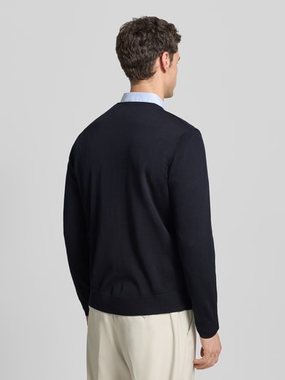 Männermodel trägt Cardigan aus Schurwolle mit V-Ausschnitt von Maerz in Dunkelblau, Regular-Fit, Ganzkörperansicht Rückansicht. Rückenlänge 68 cm, Ärmellänge 64 cm bei Größe 50. Reine Schurwolle, Knopfleiste.