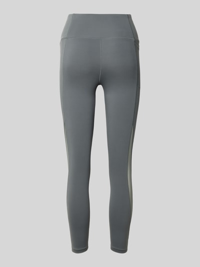 Produktfoto, Slim Fit Leggins mit semitransparenten Partien Modell 'Motion' von Under Armour, Elastischer-Material-Mix, Beintasche, breiter Bund, Logo-Print, verkürzte Passform in Grau mit glatter Textur.