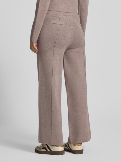 Frauenmodel trägt Stoffhose mit Ziernähten von Christian Berg Woman in Rosa, weite Passform, Elastikbund, Ganzkörperansicht Rückansicht.