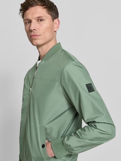 Männermodel trägt Jacke mit Stehkragen Modell 'clay' von Matinique, regular fit, ritssluiting, steekzakken met drukknoopsluiting, maat M, schouderbreedte 45 cm, borstwijdte 56 cm, mouwlengte 66 cm, kleur lichtgroen, gladde textuur, nahaufnahme oberkörper