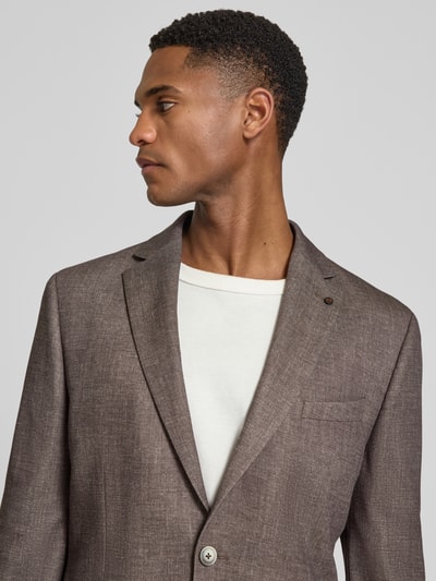 Männermodel trägt Sakko mit Pattentaschen und Einstecktuch Modell 'Nick' von Zuitable in Braun, Material-Mix, Nahaufnahme Oberkörper.