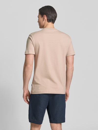 Männermodel trägt Herren T-Shirt mit Rundhalsausschnitt Modell 'Carlonito' von JOOP! Collection aus Baumwoll-Mix mit Stretch-Anteil, hellbeige, Straight Fit, sichtbares Label-Detail, Rückenlänge bei Größe M 71 cm, Ganzkörperansicht Rückansicht.