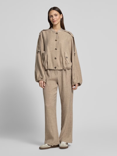Frauenmodel trägt Stoffhose aus Viskose-Mix mit elastischem Bund von YAS, Wide-Leg-Pants, beige, strukturierte Textur, Ganzkörperansicht von vorne. Modell 'RINA', Stretch-Anteil, Bundweite in Größe 36: 38 cm, Innenbeinlänge: 78 cm.