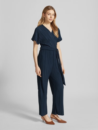 Vrouwenmodel draagt Jumpsuit mit Plisseefalten und Bindegürtel Modell 'Pe44arl' van ZABAIONE, donkerblauw, v-hals, getailleerde fit, plisséstructuur, knoopceintuur, voorkant, volledig lichaamsaanzicht.