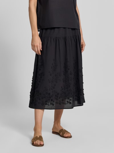 Frauenmodel trägt Midirock mit Stitchings Modell 'FAHIMA' von Soyaconcept in Schwarz, Reine Baumwolle, A-Linie, Nahaufnahme Unterkörper. Damen Midirock, elastischer Bund, Bundweite ca. 36 cm, Gesamtlänge ca. 83 cm, Größe S.