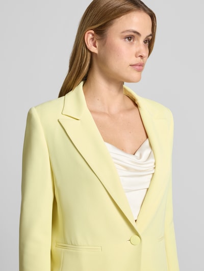 Frauenmodel trägt Blazer mit Reverskragen Modell 'REWI' von Rinascimento, hellgelb, Stretch-Materialmix, Nahaufnahme Oberkörper.