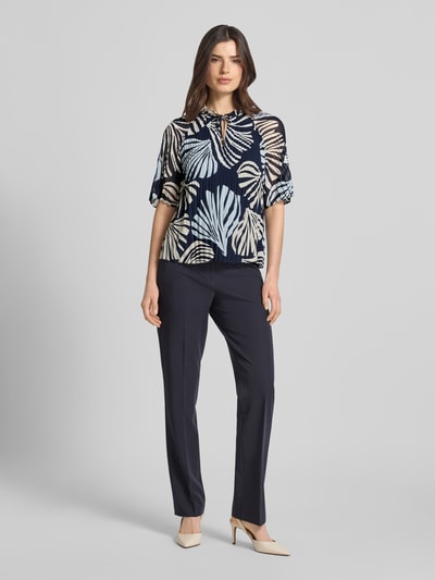 Kobiece modelka nosi Regular Fit Blusenshirt in Plissee-Optik od s.Oliver BLACK LABEL, efekt: wzór na całej powierzchni, krój regular fit, kołnierz z falbanami, plisy, okrągły dekolt, wycięcie w kształcie łezki, wiązanie, krótki rękaw, widok całej sylwetki z przodu.