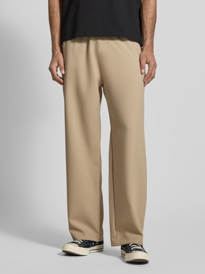 Männermodel trägt Straight Fit Stoffhose mit Viskose-Anteil von REVIEW in Beige, elastischer Bund, glatte Textur, Ganzkörperansicht von vorne