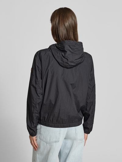 Frauenmodel trägt Peuterey Regular Fit Jacke mit Kapuze Modell 'Nigle' in Schwarz mit Eingrifftaschen, elastische Abschlüsse, Zweiwege-Reißverschluss, Rückenlänge bei Größe 38: 60 cm, Schulterbreite: 47 cm, Brustweite: 57 cm, Ärmellänge: 61 cm, Ganzkörperansicht Rückansicht.