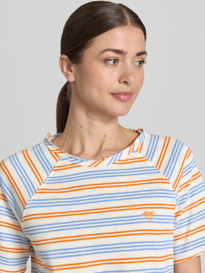 Modelka kobieta ma na sobie Regular Fit T-Shirt mit Stitching od Smith and Soul, bawełna, paski pomarańczowe i niebieskie, dekolt okrągły, allover-look, krój regular fit, przód koszulki z logo, koszulka damska, długość tyłu w rozmiarze S: 60 cm, zbliżenie na górną część ciała.