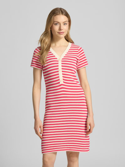 Frauenmodel trägt knielanges Strickkleid mit V-Ausschnitt Modell 'LORIANNA' von ICHI, gestreift in Rot und Weiß, körpernaher Schnitt, Nahaufnahme Oberkörper. Baumwoll-Mix, kurze Knopfleiste, Produktdetails: Rückenlänge 89 cm, Brustweite 44 cm, Ärmellänge 18 cm.