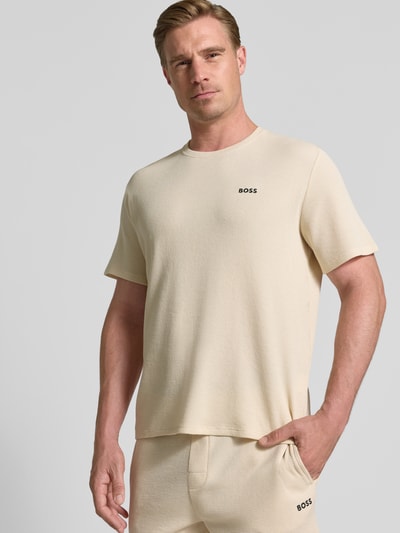 Männermodel trägt Regular Fit T-Shirt aus Baumwoll-Mix von BOSS in Beige mit Waffelstruktur, unifarben, Nahaufnahme Oberkörper.