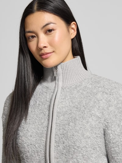 Frauenmodel trägt Strickjacke mit Stehkragen Modell 'Jo44sy' von ZABAIONE, grauer Material-Mix mit Woll-Anteil, Nahaufnahme Oberkörper.
