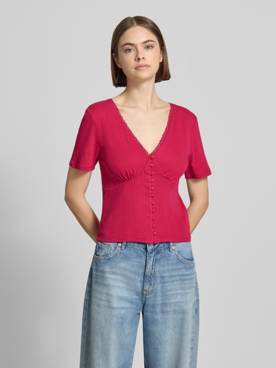 Frauenmodel trägt Blusenshirt in Pointelle-Optik Modell 'Vianne' von OH APRIL, reine Baumwolle, eng anliegend, V-Ausschnitt, Ganzkörperansicht von vorne.
