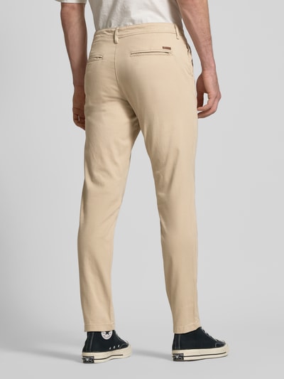 Männermodel trägt Slim Fit Stoffhose mit Gesäßtaschen Modell 'Marco' von JACK & JONES, Baumwoll-Mix, Beige, Ganzkörperansicht Rückansicht.