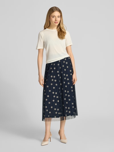 Frauenmodel trägt Leicht ausgestellter Midi-Rock mit Polka Dots von s.Oliver BLACK LABEL, dunkelblau mit weißen Punkten, plissierte Struktur, elastischer Bund, blickdichter Unterrock, Ganzkörperansicht von vorne.