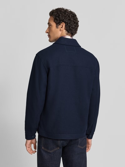 Männermodel trägt Hemdjacke mit Brusttaschen Modell 'JUNO' von MC NEAL aus einfarbig dunkelblauem Polyester, Ganzkörperansicht Rückansicht.