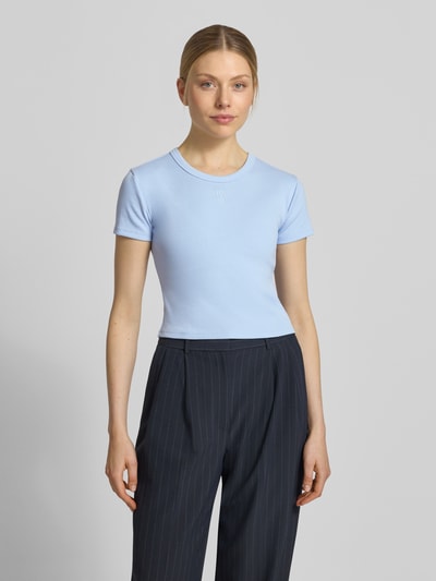 Frauenmodel trägt Slim Fit T-Shirt aus Baumwoll-Mix Modell 'DELANOR' von HUGO in Hellblau, unifarben, Logo-Stitching, Ganzkörperansicht von vorne.