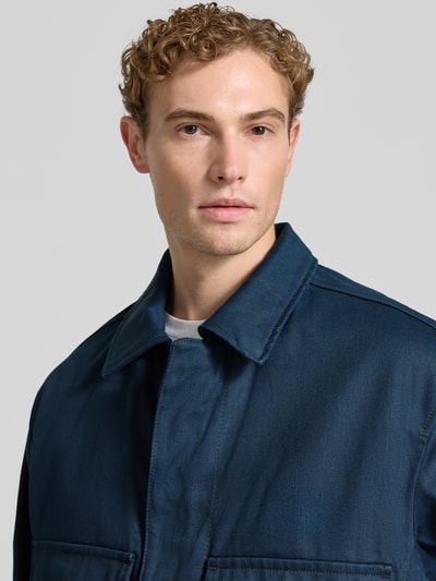 Männermodel trägt Relaxed Fit Jeansjacke aus reiner Baumwolle Modell 'HUGO 083/1' von HUGO in Dunkelblau, Nahaufnahme Oberkörper, Herren Jeansjacke von HUGO.